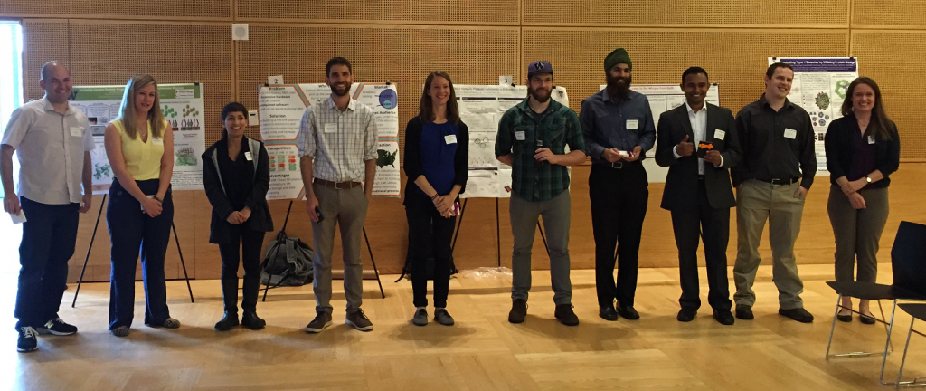 Recent UWIN Awardees stand in a line in front of their posters.