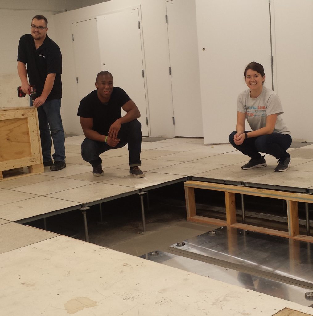 Dave from Bertec, Darrin our new research scientist, and Keshia our lab manager and research scientist look in the sub-floor space where the new split-belt treadmill will be installed.