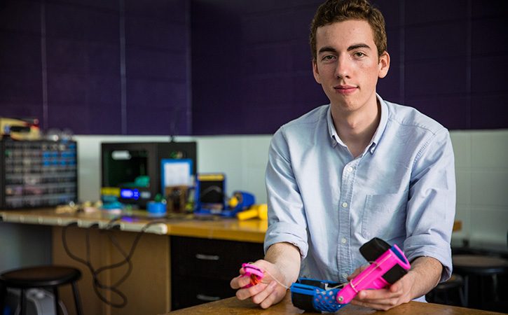 Bradley Wachter poses with an orthotic device he co-designed with team members