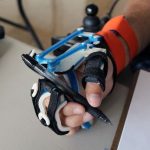 User wearing wrist driven orthosis and holding pen