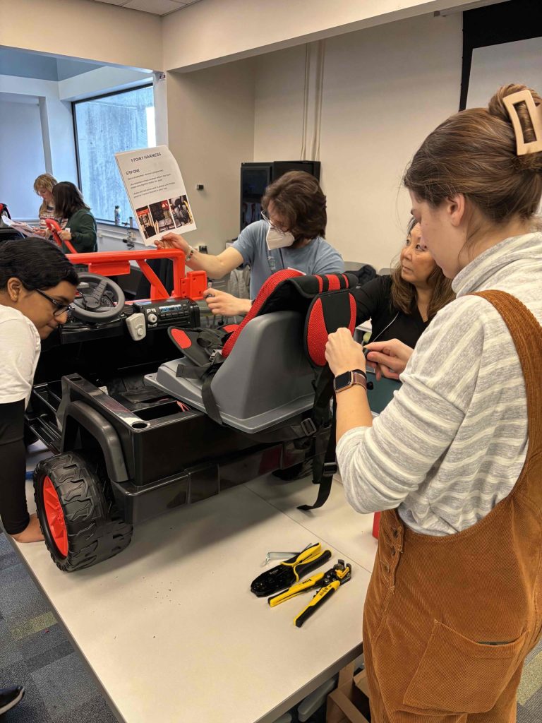 A group of people building their Go Baby Go Car