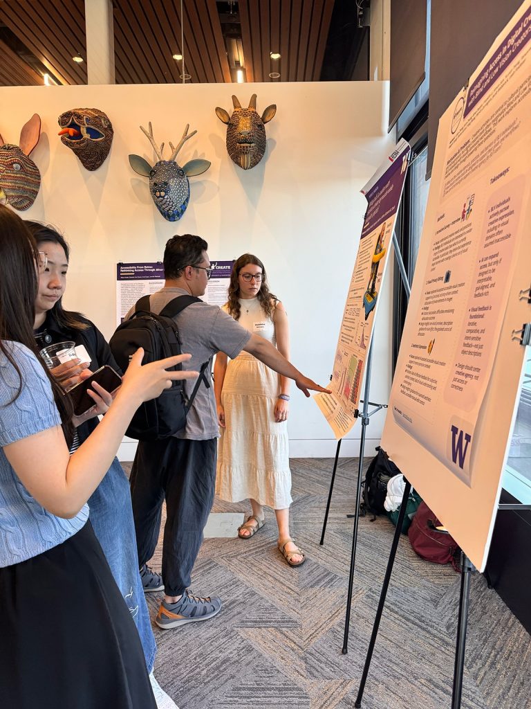 A group of people viewing academic posters displayed on easels at a research showcase.
